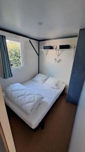 a large bed in a room with a window at Bungalow bord de mer in Les Mathes