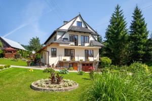 a house with a garden in front of it at Apartament U Jagody in Tylicz