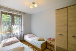 a bedroom with two beds and a window at Apartament U Jagody in Tylicz +7 photos