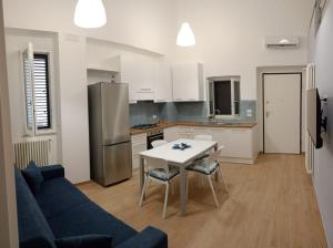 a kitchen with a blue couch and a table and a refrigerator at Life to Home in Bernalda