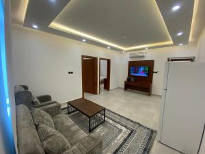 a living room with a couch and a tv at قصر أباهي للوحدات السكنية المفروشة in Al Nairyah