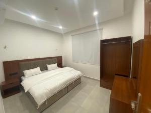 a bedroom with a large bed with white sheets at قصر أباهي للوحدات السكنية المفروشة in Al Nairyah +12 photos