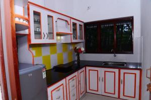 a kitchen with red and white cabinets and a sink at Sea view beach view beautiful villa in Trivandrum
