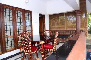 a dining room with a table and chairs and windows at Sea view beach view beautiful villa in Trivandrum +7 photos