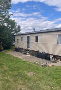 a mobile home with a porch and a yard at Allhallows getaway in Rochester
