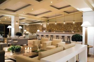 a lobby of a hotel with chairs and a bar at Sani Club in Sani Beach