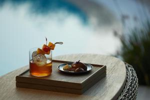 a tray with a drink and a plate of food on a table at Sani Club in Sani Beach