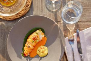 a plate of food with a fish and vegetables on a table at Sani Club in Sani Beach