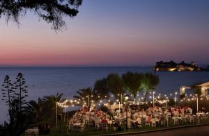 a group of people sitting in chairs at a restaurant at night at Sani Club in Sani Beach