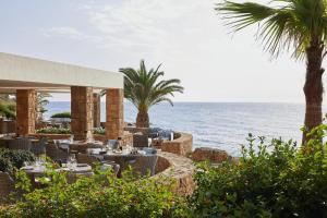 a restaurant on the beach with the ocean in the background at Sani Club in Sani Beach