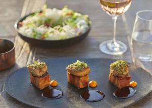 a plate of food on a table with a glass of wine at Sani Club in Sani Beach