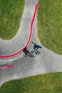 a man riding a skateboard down a road with a shadow at Sani Club in Sani Beach