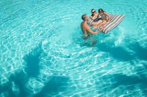 two people sitting on a raft in the water at Sani Club in Sani Beach