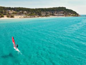 a person riding a surfboard in the ocean at Sani Club in Sani Beach