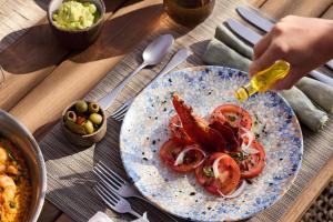 a plate of food with shrimp and tomatoes on a table at Ikos Andalusia in Estepona +266 photos