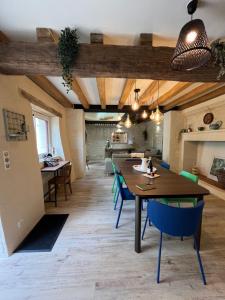 a dining room with a table and blue chairs at Gîte du Puits Chauveau Spa Vignes Chateaux 8pers in Ligré