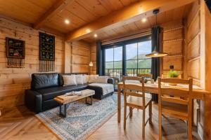 een woonkamer met een bank en een tafel bij Nowy Szlak Luksusowe Apartamenty in Kościelisko +73 foto's