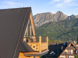 een huis met een terras met bergen op de achtergrond bij Nowy Szlak Luksusowe Apartamenty in Kościelisko