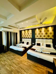 a hotel room with three beds in it at Hotel Kabir Residency in Amritsar