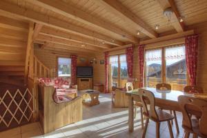 una sala da pranzo e un soggiorno in una baita di tronchi di Chalet Makaau - Praz de Lys a Taninges