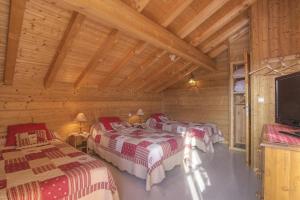 una camera con due letti in una baita di legno di Chalet Makaau - Praz de Lys a Taninges