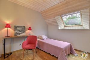 a bedroom with a bed and a desk and a window at La maison des charretiers in Cohiniac
