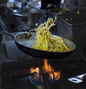 a bowl of noodles on top of a stove at Rifugio Baita Belvedere in Champoluc