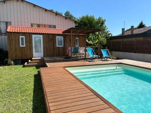 Un patio trasero con piscina y una casa. en Chalet de jardin, piscine, en Seignosse