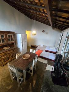 a kitchen with a table and a refrigerator and a bed at Stay Cool Pipa in Pipa