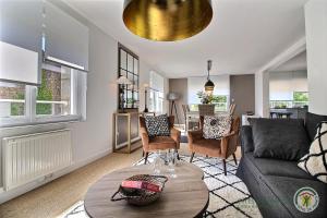 una sala de estar con un sofá y una mesa en Sous le cerisier, en Créhen