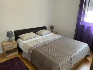 a bedroom with a bed with two pillows and a window at Oaza mira in Podstrana