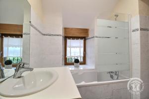 Baño blanco con lavabo y bañera en La vallee de leber, en Plouasne 37 fotos más