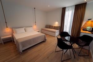 a bedroom with a bed and a table and chairs at Hotel Vila 19 in Dhërmi