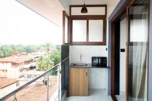 a kitchen with a sink and a balcony with a view at Casa Quina Heritage#5 in Taleigao