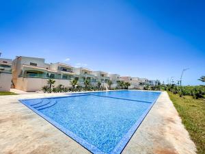 a swimming pool in front of a house at Villa de luxe résidence front de mer 50m de la mer in Tamaris