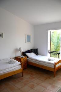 2 camas en una habitación con ventana en Villa Kalisorate, en Tsadha
