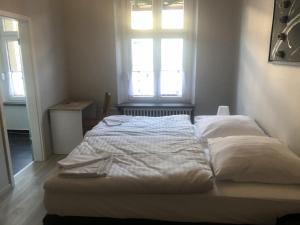 ein weißes Bett in einem Zimmer mit Fenster in der Unterkunft Hotel Schwaferts in Wuppertal