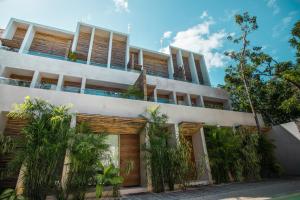 an apartment building with plants in front of it at Samiik by Arkylab in Tulum