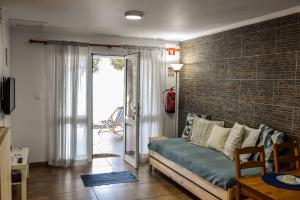 a living room with a couch and a brick wall at Casa dos Terreiros Oceanfront Villa in Manadas