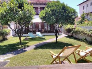 a group of chairs sitting in the grass at Orsiida Seaside Cottage KGatzea in Kato Gatzea
