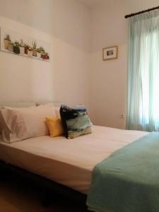 a bed with pillows on it in a bedroom at Orsiida Seaside Cottage KGatzea in Kato Gatzea +43 photos