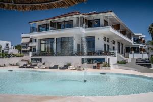 a large house with a swimming pool in front of it at Elion Seaside Resort in Eretria