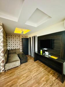 a living room with a couch and a television at Hotel Kabir Residency in Amritsar