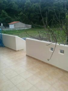 a white retaining wall in a yard with a tree at Angel in Káto Alepokhórion