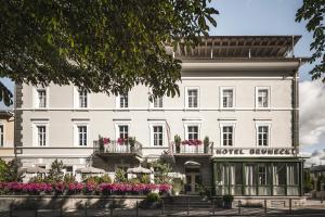 a large white building with flowers in front of it at Hotel Bruneck Design-Suites in Brunico