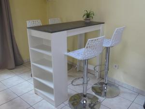 a white island with two chairs and a counter at Au Bonheur Suspendu in Pont-en-Royans