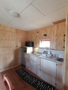 een kleine keuken met een spoelbak en een fornuis bij Chon-Vilú in Chonchi +2 foto's