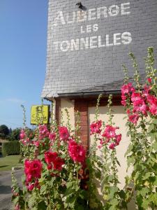 Saint-LéonardにあるAuberge Les Tonnellesのピンクの花が目の前に咲く建物