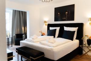 a bedroom with a large white bed with a black headboard at JUNIK Apartments "Am Sternbuschweg" in Duisburg
