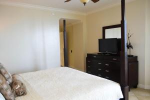 a bedroom with a bed and a mirror and a television at Beach Colony 18A in Pensacola